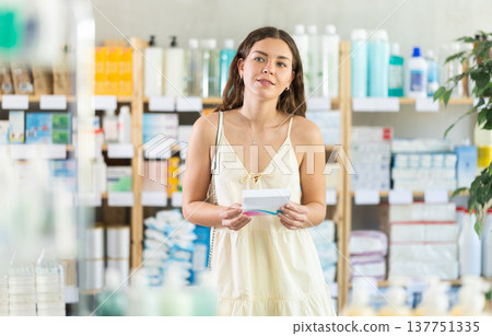 woman chooses a package of pills in the summer at the pharmacy woman chooses a package of pills in the summer at the pharmacy 137751335