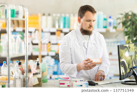 Experienced pharmacist offers various medicines and ointments in pharmacy 137751349