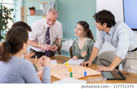 Young students and a teacher playing educational board game 137751354