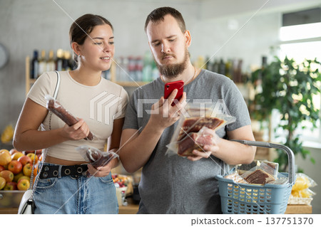 couple scans the QR code of meat products on their phone couple scans the QR code of meat products on their phone 137751370
