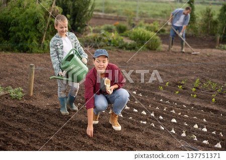 Woman and her son plant seeds 137751371