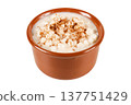 Canjica, mungunza, a Brazilian dessert made with white corn and sprinkled with cinnamon, in a handcrafted brown ceramic bowl isolated on a white background 137751429