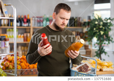 Grocery shopping - man chooses juice in supermarket 137751680