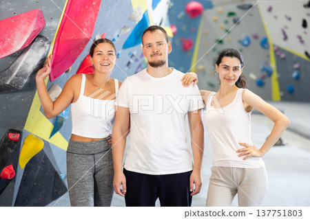 Man and two women pose on climbing wall 137751803
