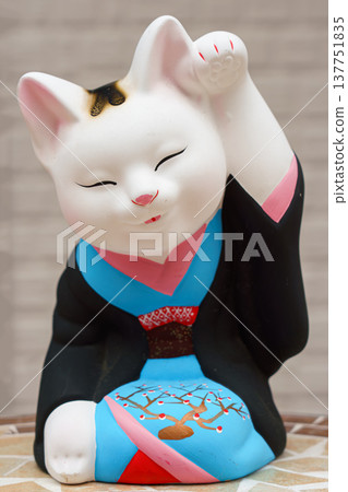 Tokyo, Japan - Sep 30 2024, vertical view of the sculpture of a seated smiling beckoning cat Maneki Neko dressed in a black and blue kimono, Tokyo, Japan Tokyo, Japan - Sep 30 2024, vertical view of the sculpture of a seated smiling beckoning cat Maneki Neko dressed in a black and blue kimono, Tokyo, Japan 137751835