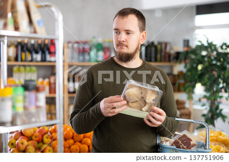 Man holds a package of oyster mushrooms in his hands Man holds a package of oyster mushrooms in his hands 137751906