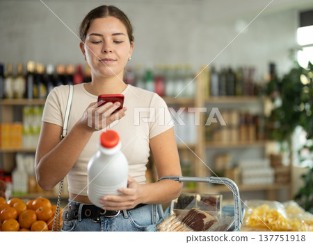 Young woman scanning qr code of milk 137751918