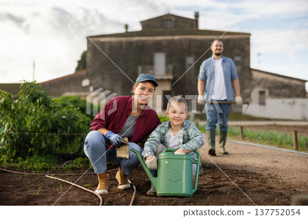 Woman with her son in the garden on the farm Woman with her son in the garden on the farm 137752054