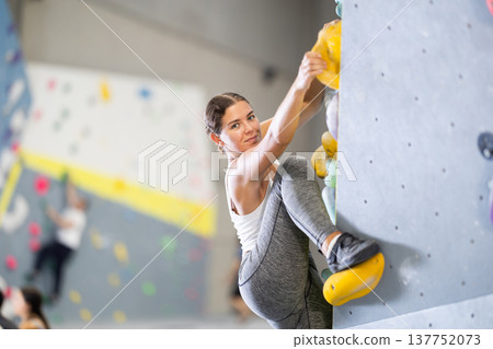 Young woman practicing rock climbing on climbing wall Young woman practicing rock climbing on climbing wall 137752073