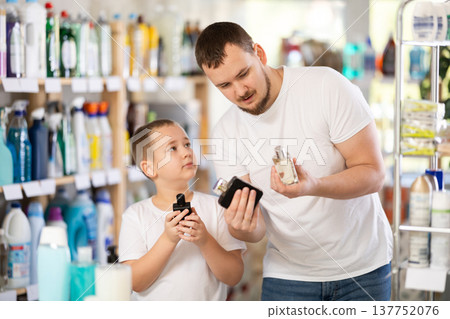 Dad and son client sniffs fragrance of perfume, chooses scent spray with pleasant smell Dad and son client sniffs fragrance of perfume, chooses scent spray with pleasant smell 137752076