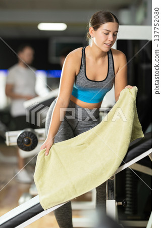 Woman putting a towel on the machine Woman putting a towel on the machine 137752080