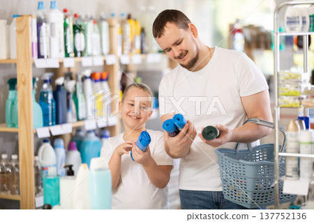 Man and boy choosing garbage bags in store Man and boy choosing garbage bags in store 137752136