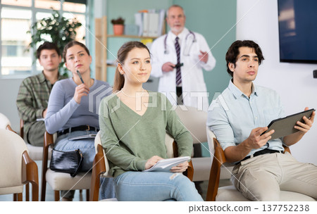 Students listen to lecture in classroom, with medical professor in background Students listen to lecture in classroom, with medical professor in background 137752238