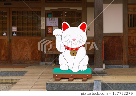 Tokyo, Japan - Sep 30 2024, Close-up view of the flat plywood figure of the beckoning white cat Maneki Neko, at the entrance to Gotokuji Temple, at daytime, without people, Tokyo, Japan Tokyo, Japan - Sep 30 2024, Close-up view of the flat plywood figure of the beckoning white cat Maneki Neko, at the entrance to Gotokuji Temple, at daytime, without people, Tokyo, Japan 137752279