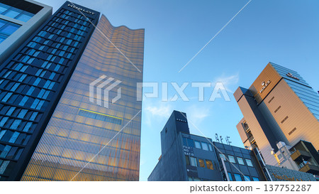 Tokyo, Japan - Oct 14 2024, A panoramic view from below of the glass facades of skyscrapers in the Ginza district, against the backdrop of a clear blue sky, in the evening, Tokyo, Japan Tokyo, Japan - Oct 14 2024, A panoramic view from below of the glass facades of skyscrapers in the Ginza district, against the backdrop of a clear blue sky, in the evening, Tokyo, Japan 137752287