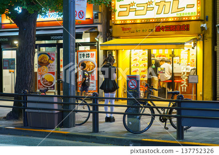 Tokyo, Japan - Oct 14 2024, panoramic view of a street in Akihabara district with female promoters in short dresses against backdrop of shop and restaurant windows, illuminated at night,Tokyo, Japan Tokyo, Japan - Oct 14 2024, panoramic view of a street in Akihabara district with female promoters in short dresses against backdrop of shop and restaurant windows, illuminated at night,Tokyo, Japan 137752326