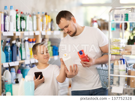 Schoolboy son and dad are choosing unclogging agent in store Schoolboy son and dad are choosing unclogging agent in store 137752328