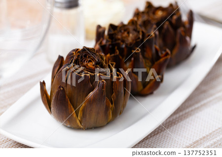Top view of vegetarian appetizer of baked artichokes served on plate 137752351