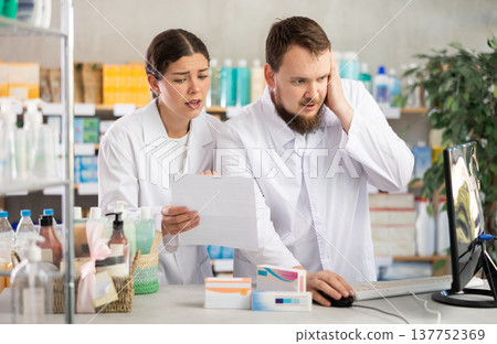 Two pharmacists annoyed near the computer Two pharmacists annoyed near the computer 137752369