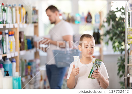 Schoolboy choosing toothbrush in store Schoolboy choosing toothbrush in store 137752442