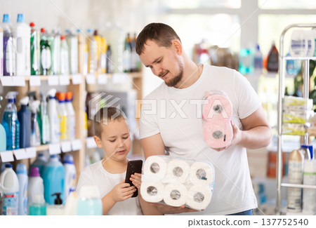 Man and boy choosing toilet paper in store 137752540