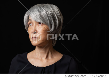 一位白髮蒼蒼的老婦人斜向上凝視。 137752853
