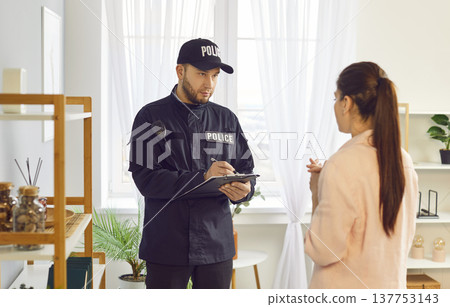 Police Officer Or Detective Investigating Crime And Interviewing Female Victim 137753143