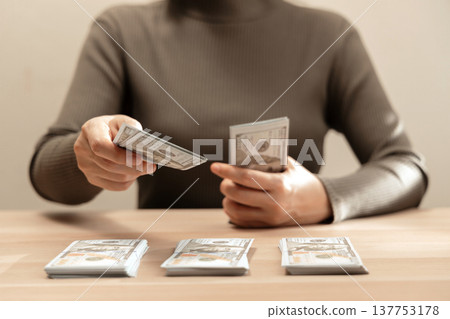 Sorting cash money into piles on a wooden table. Personal finance, money management 137753178