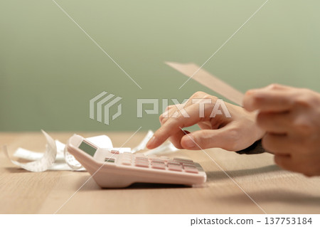 Using calculator to calculate bills and expenses, representing household budgeting, expense control 137753184