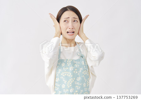 一位女士戴著圍裙遮住耳朵，白色背景 137753269