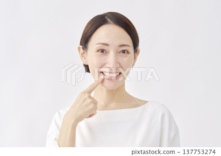 Woman pointing at her mouth, oral care image, white background Woman pointing at her mouth, oral care image, white background 137753274