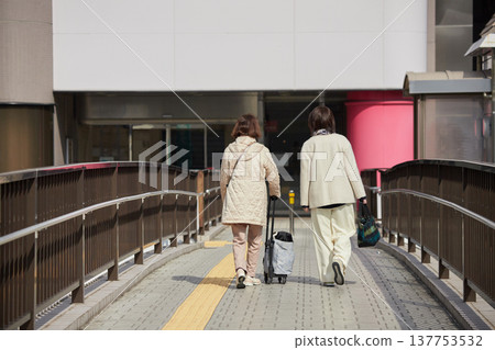 冬日清晨，幾位中年婦女走過熙熙攘攘的市中心人行天橋。 137753532