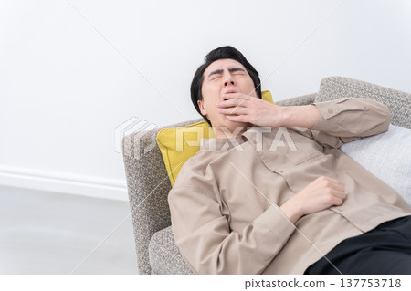 A man sleeping on the sofa 137753718