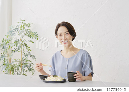 A woman eating Zaru Udon noodles in the living room 137754045