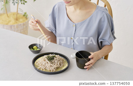 A woman eating zaru soba in the living room (faceless) 137754050