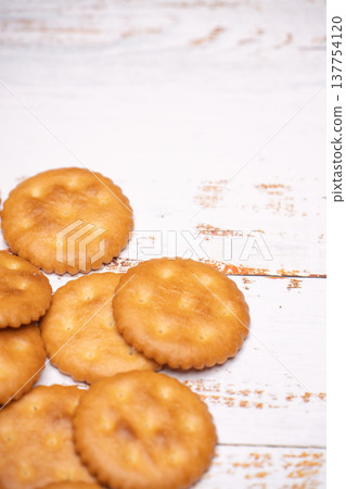 A still life photograph of a white wooden table and round crackers. A still life photograph of a white wooden table and round crackers. 137754120