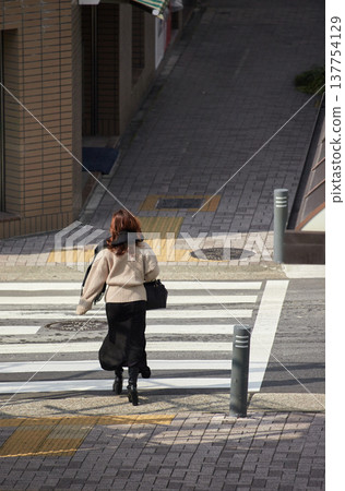 冬日清晨,一位女性在城市裡步行上班,鏡頭從高處拍攝。 冬日清晨,一位女性在城市裡步行上班,鏡頭從高處拍攝。 137754129