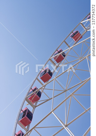 A low-angle shot of a Ferris wheel against a blue sky and copy space. A low-angle shot of a Ferris wheel against a blue sky and copy space. 137754372