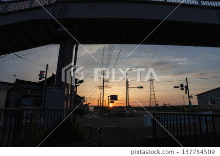 [Evening view of Shonai] Sunset sinking behind a pedestrian overpass and highway 137754509