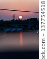 Sunset and transmission towers visible from a pedestrian overpass in the city. Sunset and transmission towers visible from a pedestrian overpass in the city. 137754518