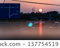 Sunset and transmission towers visible from a pedestrian overpass in the city. Sunset and transmission towers visible from a pedestrian overpass in the city. 137754519