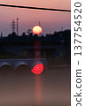 Sunset and transmission towers visible from a pedestrian overpass in the city. Sunset and transmission towers visible from a pedestrian overpass in the city. 137754520