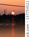 Sunset and transmission towers visible from a pedestrian overpass in the city. Sunset and transmission towers visible from a pedestrian overpass in the city. 137754521