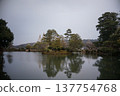 A Japanese garden with a pond and snow-covered trees: a winter scene. 137754768
