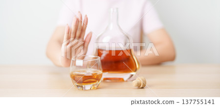 woman making stop hand gesture to refuse a glass of Cognac, Healthy man say no to alcohol drink, stop alcoholism and addiction concept. Responsible man reject a drink before driving and quit booze woman making stop hand gesture to refuse a glass of Cognac, Healthy man say no to alcohol drink, stop alcoholism and addiction concept. Responsible man reject a drink before driving and quit booze 137755141