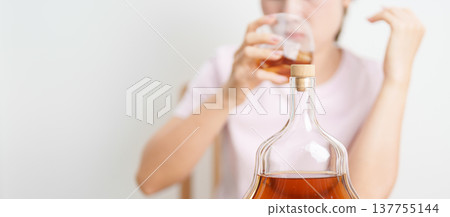 Stressed woman drinking cognac alone with problem. Exhausted drunk man looking stressed and sleepy. Alcohol addiction, Alcoholism, emotional distress and mental health concept Stressed woman drinking cognac alone with problem. Exhausted drunk man looking stressed and sleepy. Alcohol addiction, Alcoholism, emotional distress and mental health concept 137755144