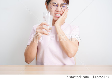 woman having toothache and pain after drink ice water for concept of Teeth Sensitive to Cold, Tooth Decay and Gum Disease, Grinding Teeth and Stress, Exposed Nerve Roots, Crack and Receding woman having toothache and pain after drink ice water for concept of Teeth Sensitive to Cold, Tooth Decay and Gum Disease, Grinding Teeth and Stress, Exposed Nerve Roots, Crack and Receding 137755167