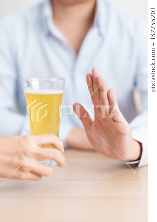 man making stop hand gesture to refuse a glass of Beer, Healthy man say no to alcohol drink, stop alcoholism and addiction concept. Responsible man reject a drink before driving and quit booze man making stop hand gesture to refuse a glass of Beer, Healthy man say no to alcohol drink, stop alcoholism and addiction concept. Responsible man reject a drink before driving and quit booze 137755201