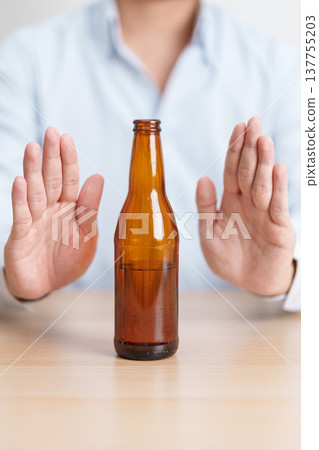 man making stop hand gesture to refuse a bottle of Beer, Healthy man say no to alcohol drink, stop alcoholism and addiction concept. Responsible man reject a drink before driving and quit booze man making stop hand gesture to refuse a bottle of Beer, Healthy man say no to alcohol drink, stop alcoholism and addiction concept. Responsible man reject a drink before driving and quit booze 137755203
