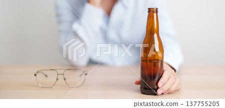 Stressed man drinking beer alone with problem. Exhausted drunk man looking stressed and sleepy. Alcohol addiction, Alcoholism, emotional distress and mental health concept 137755205